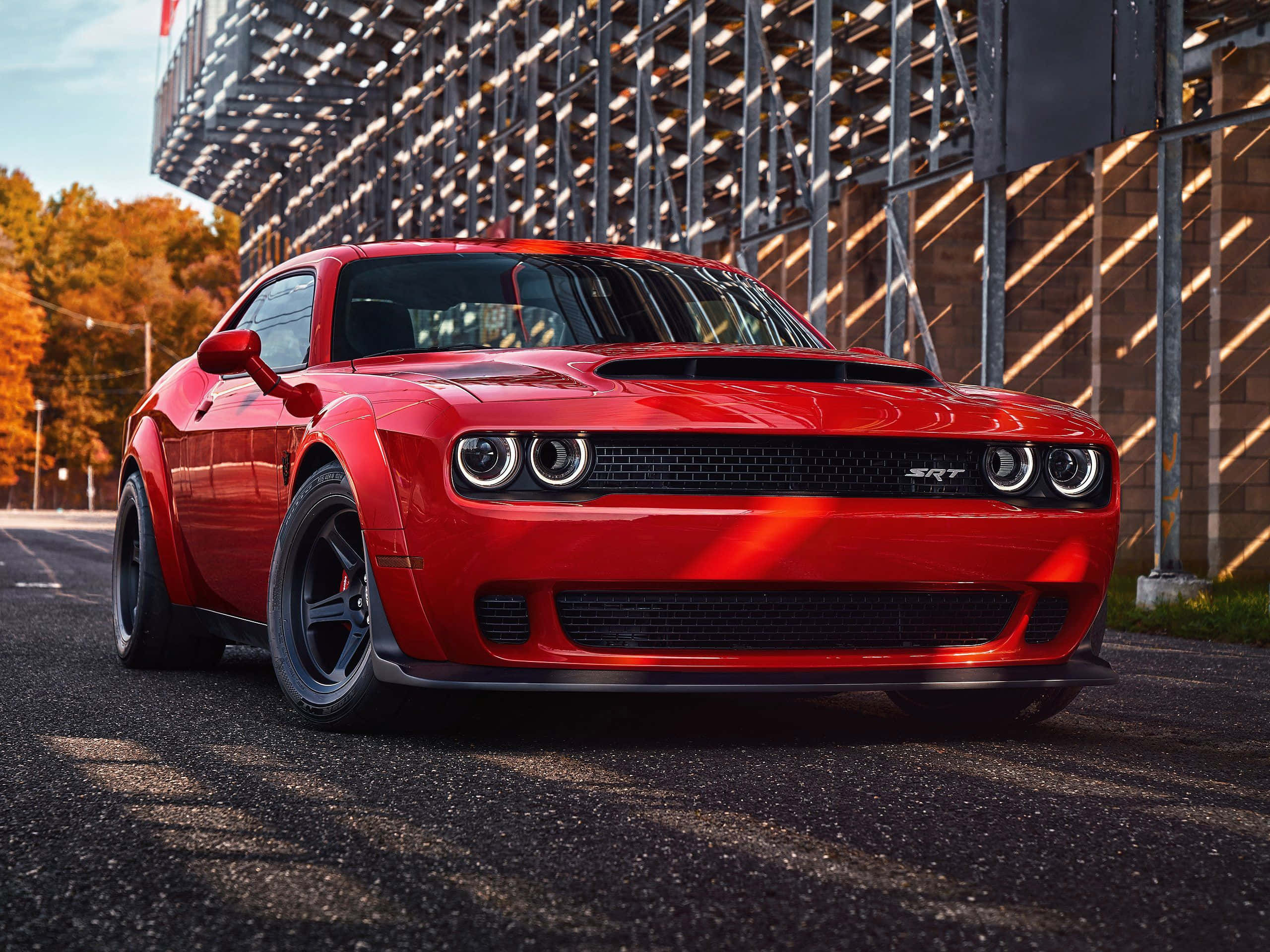 A Red Dodge Challenger Parked On A Street Background