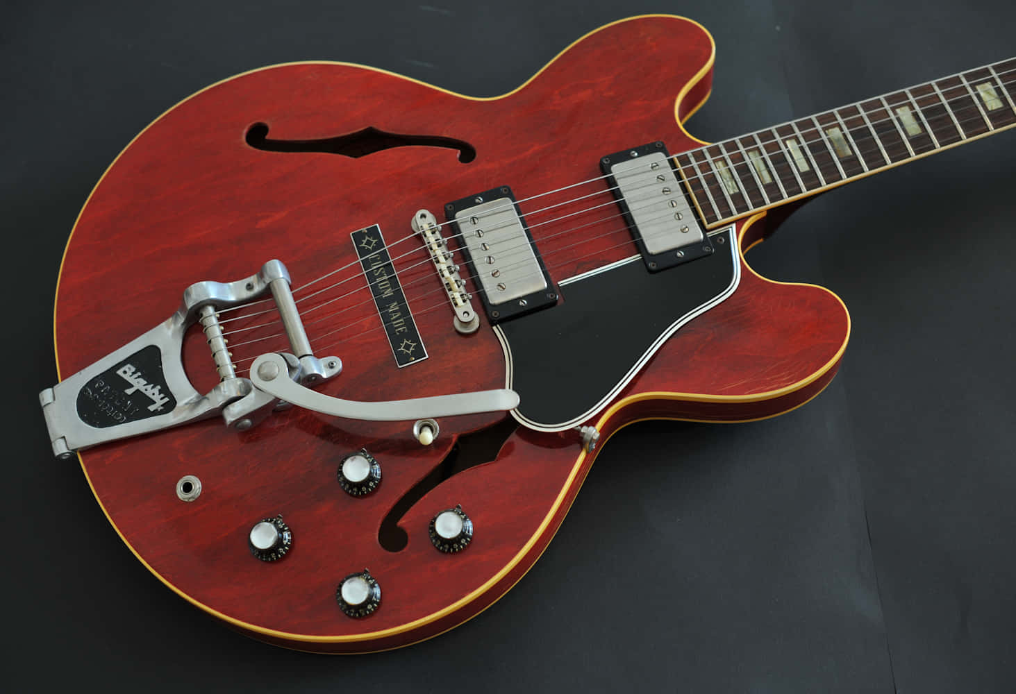 A Red Guitar With A Black Neck And A Black Body Background