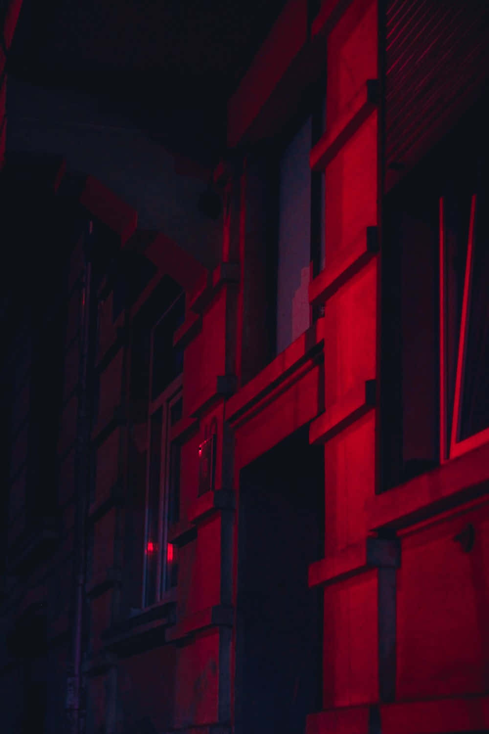 A Red Light Is Shining On A Building Background