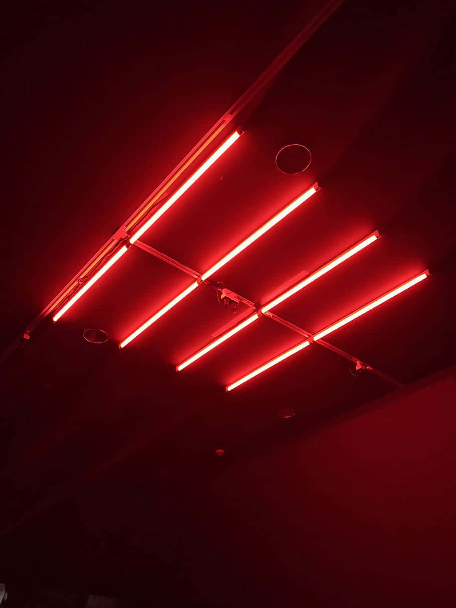 A Red Neon Light Is Hanging From The Ceiling Background