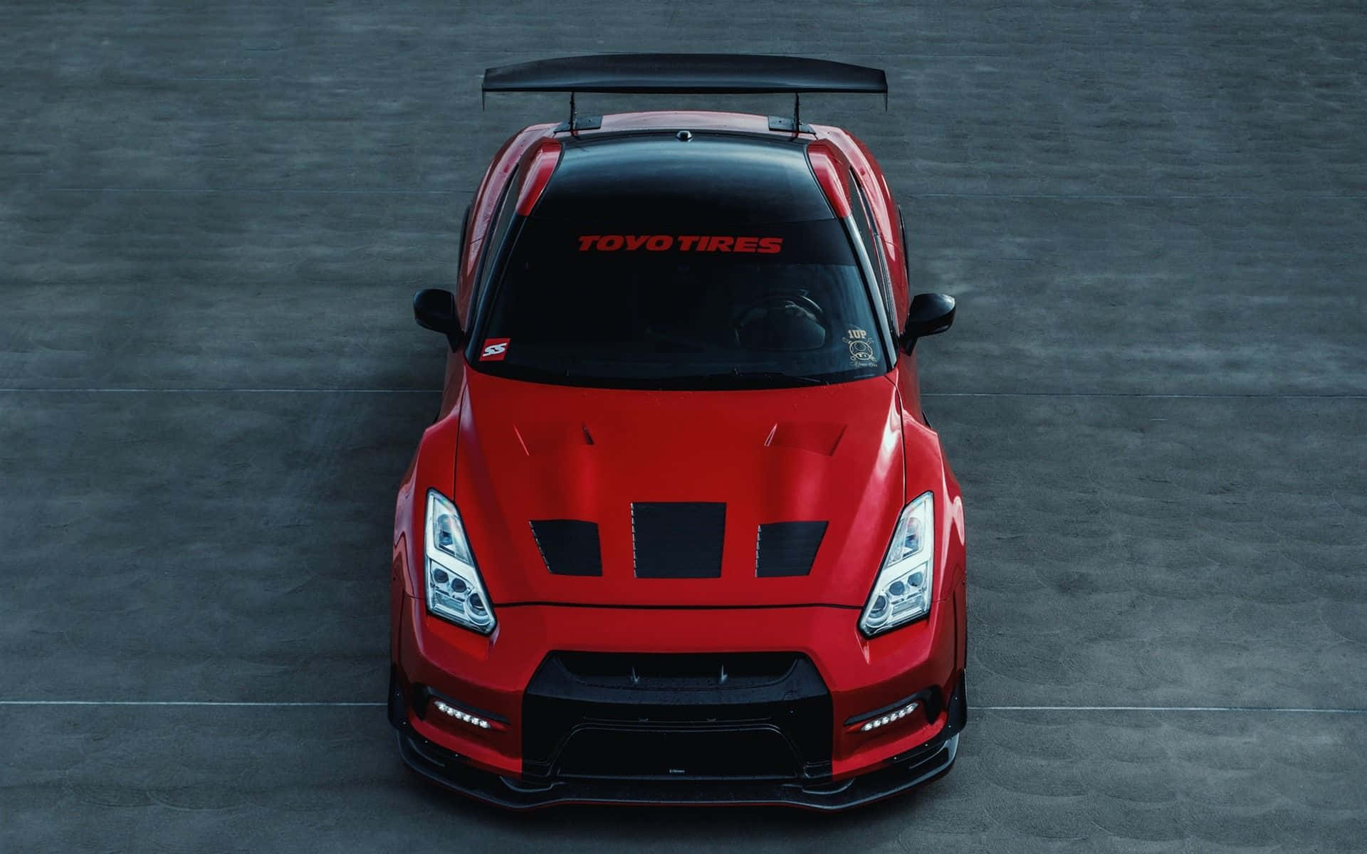 A Red Nissan Gtr - R - Is Shown In The Sky Background