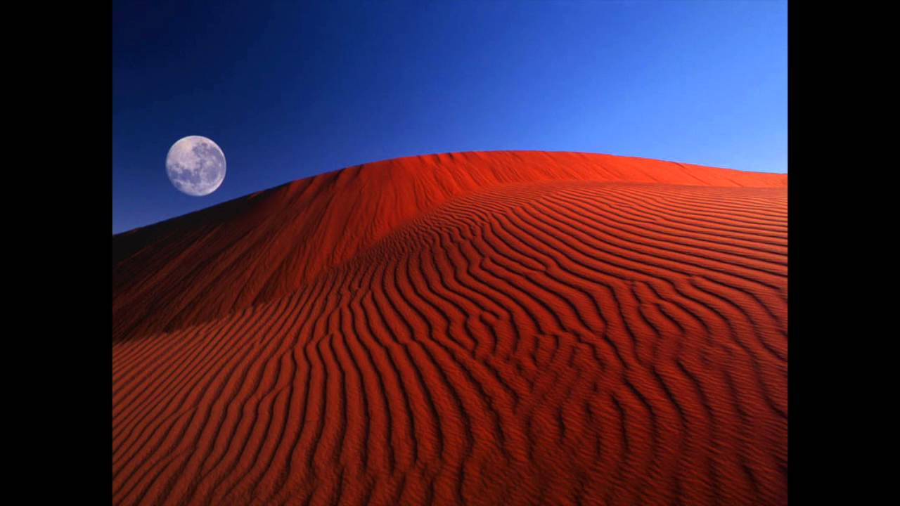A Red Sand Dune With The Moon In The Sky Background