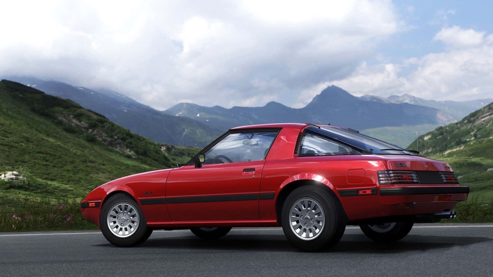 A Red Sports Car Driving Down A Mountain Road