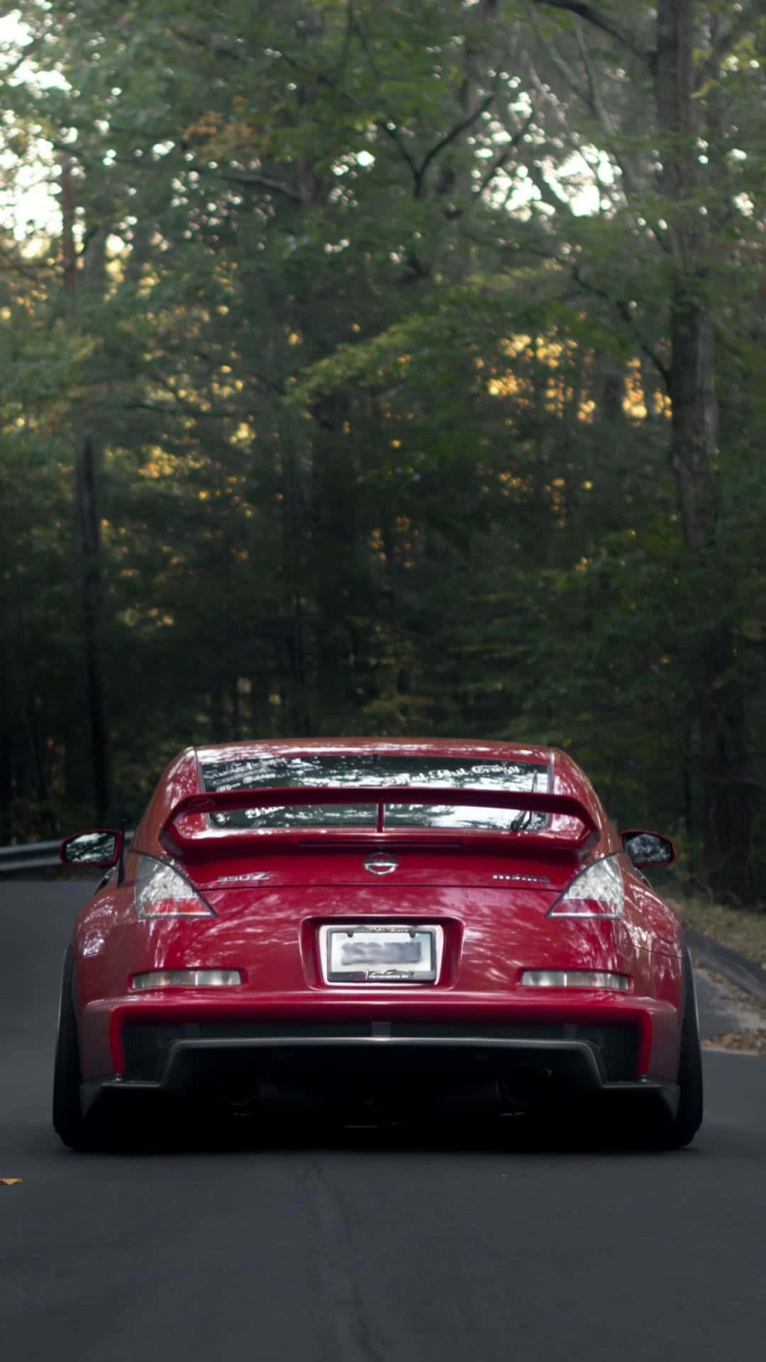 A Red Sports Car Driving Down A Road