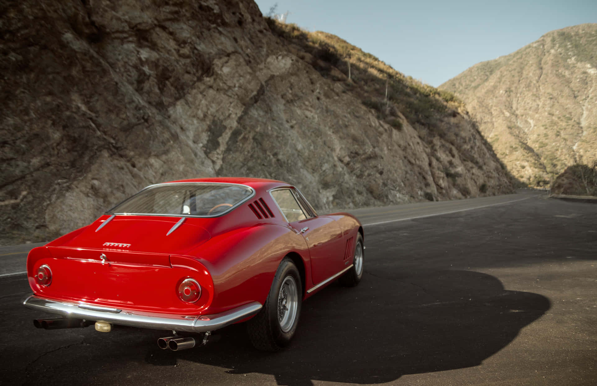 A Red Sports Car Is Parked On A Mountain Road