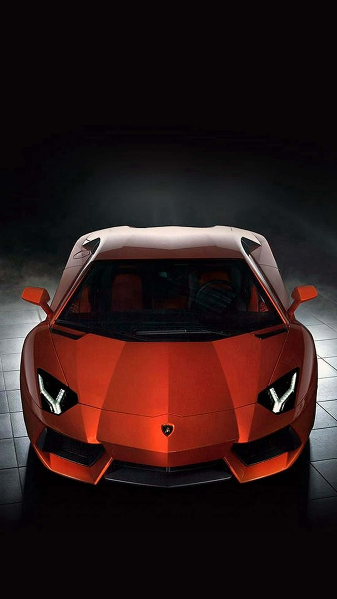 A Red Sports Car Is Shown In A Dark Room Background