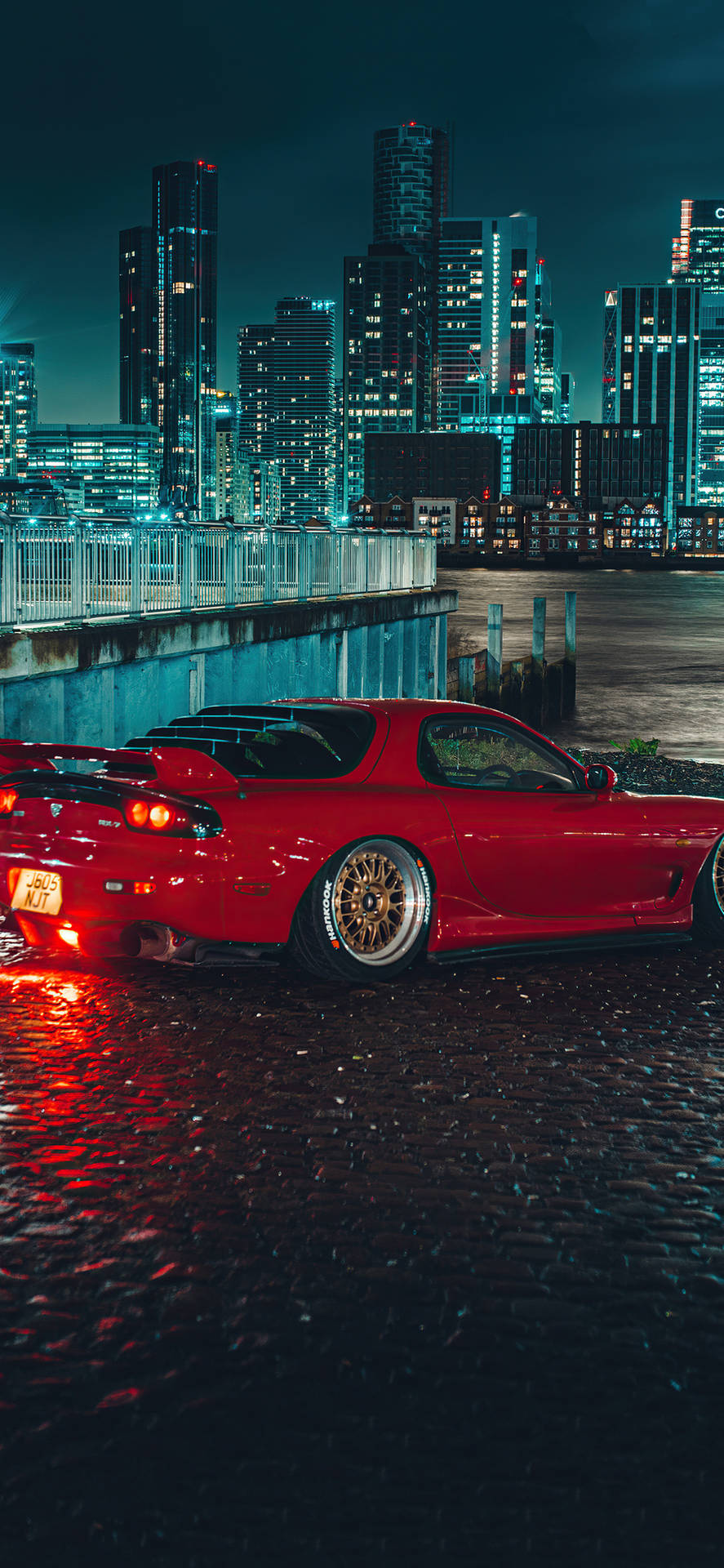 A Red Sports Car Parked In A City Background