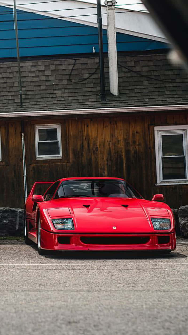 A Red Sports Car Parked In Front Of A Building