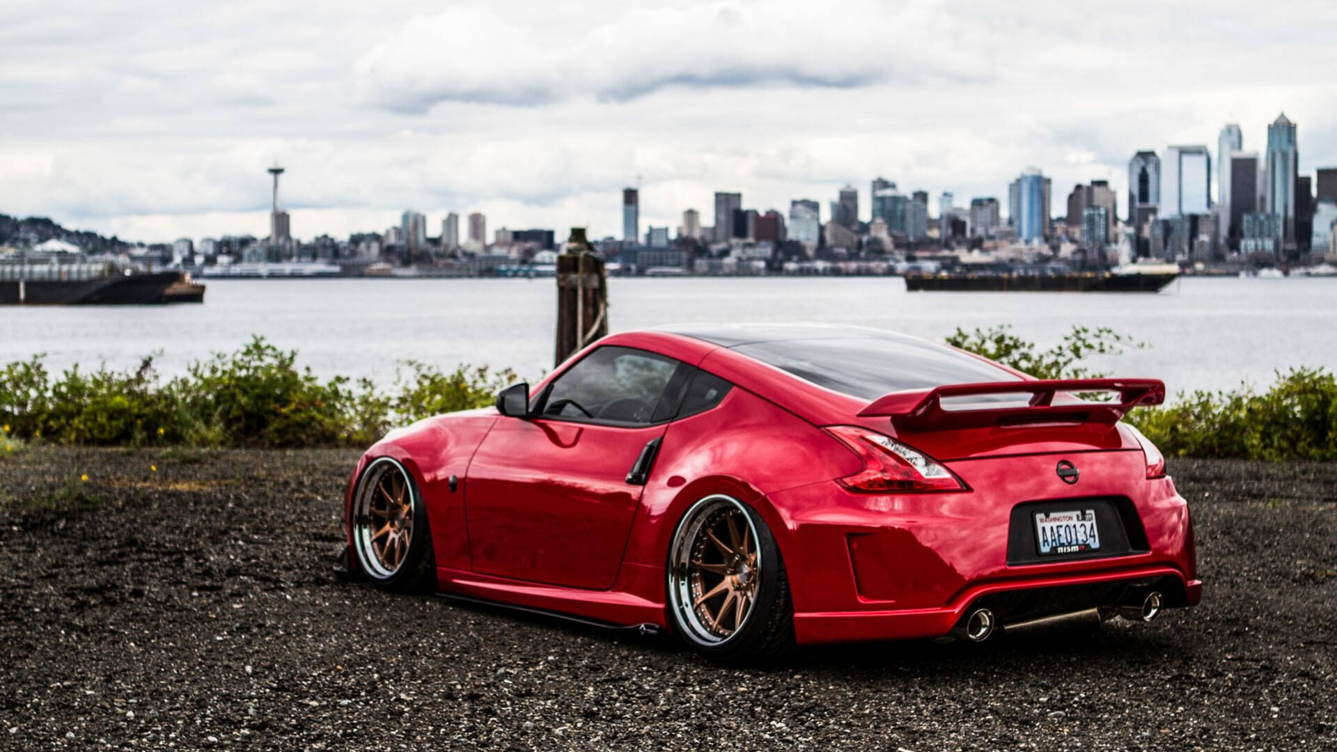 A Red Sports Car Parked In Front Of A City