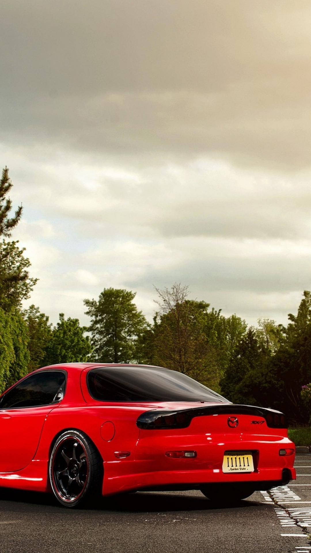 A Red Sports Car Parked On A Street Background