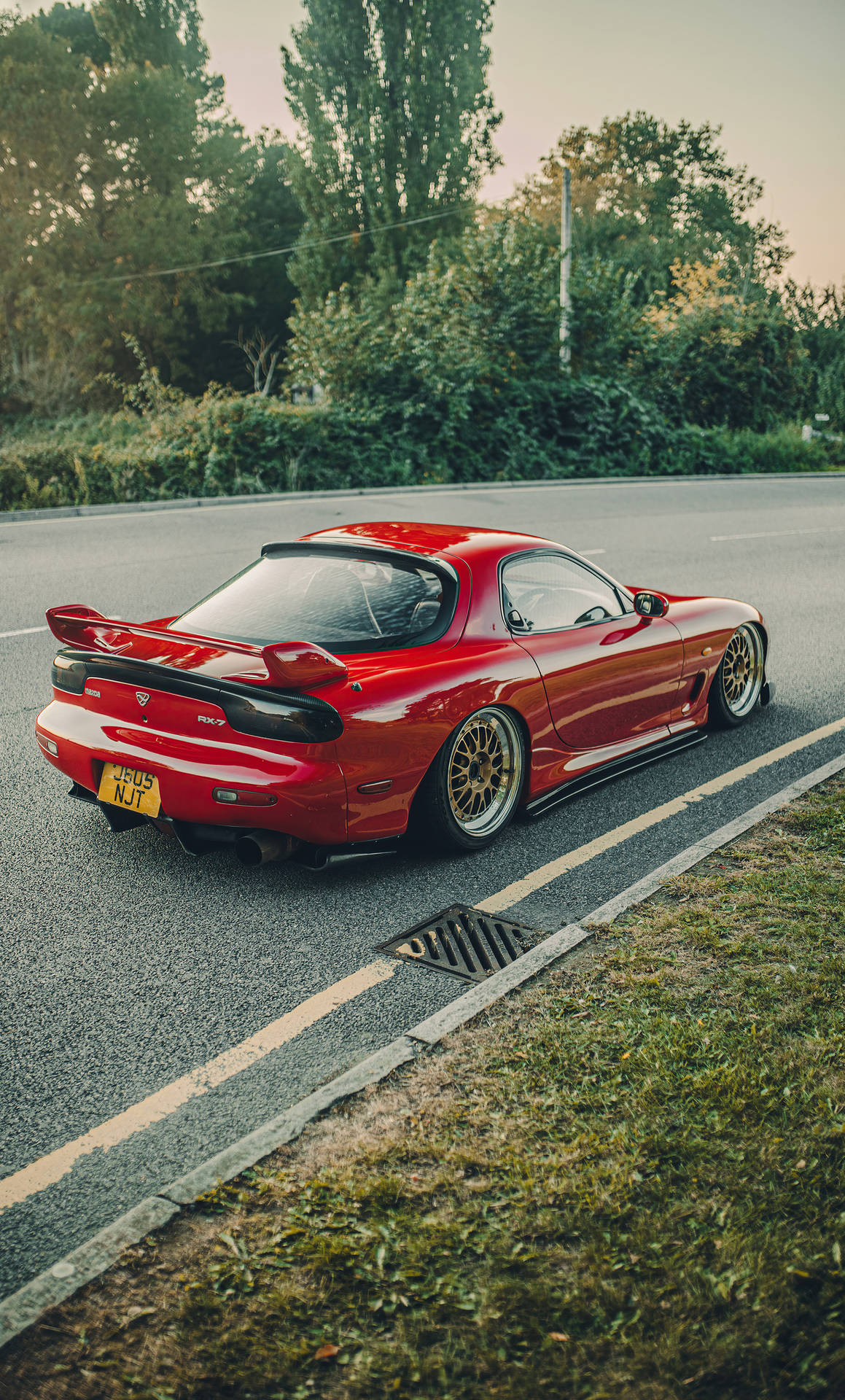 A Red Sports Car Parked On The Side Of The Road Background