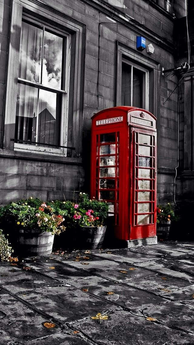 A Red Telephone Booth In Front Of A Building