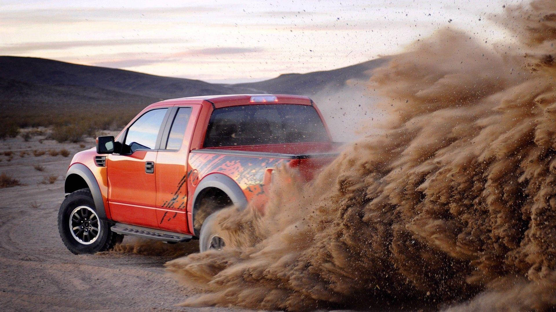 A Red Truck Driving Through A Desert