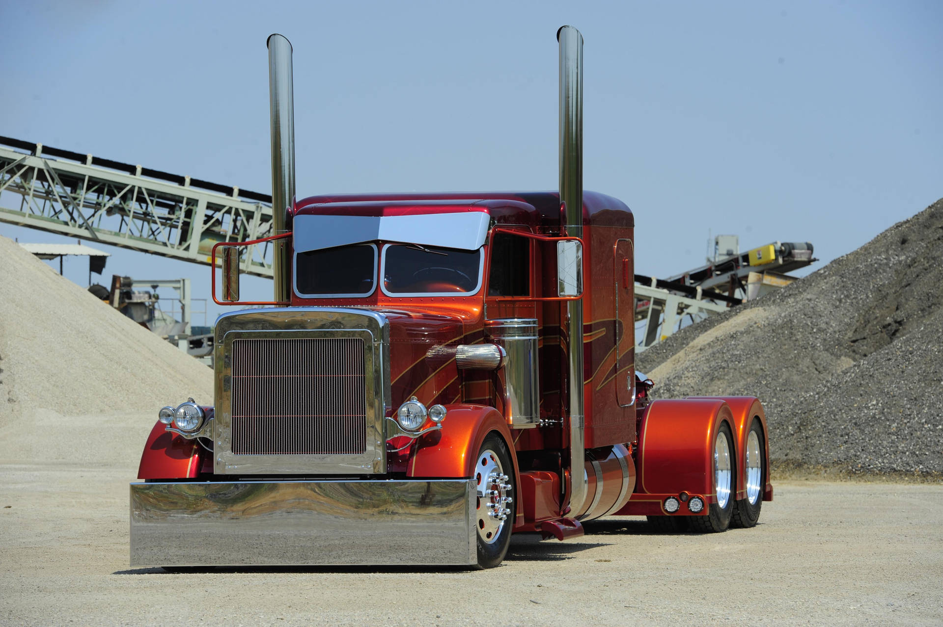 A Red Truck Parked In A Dirt Lot