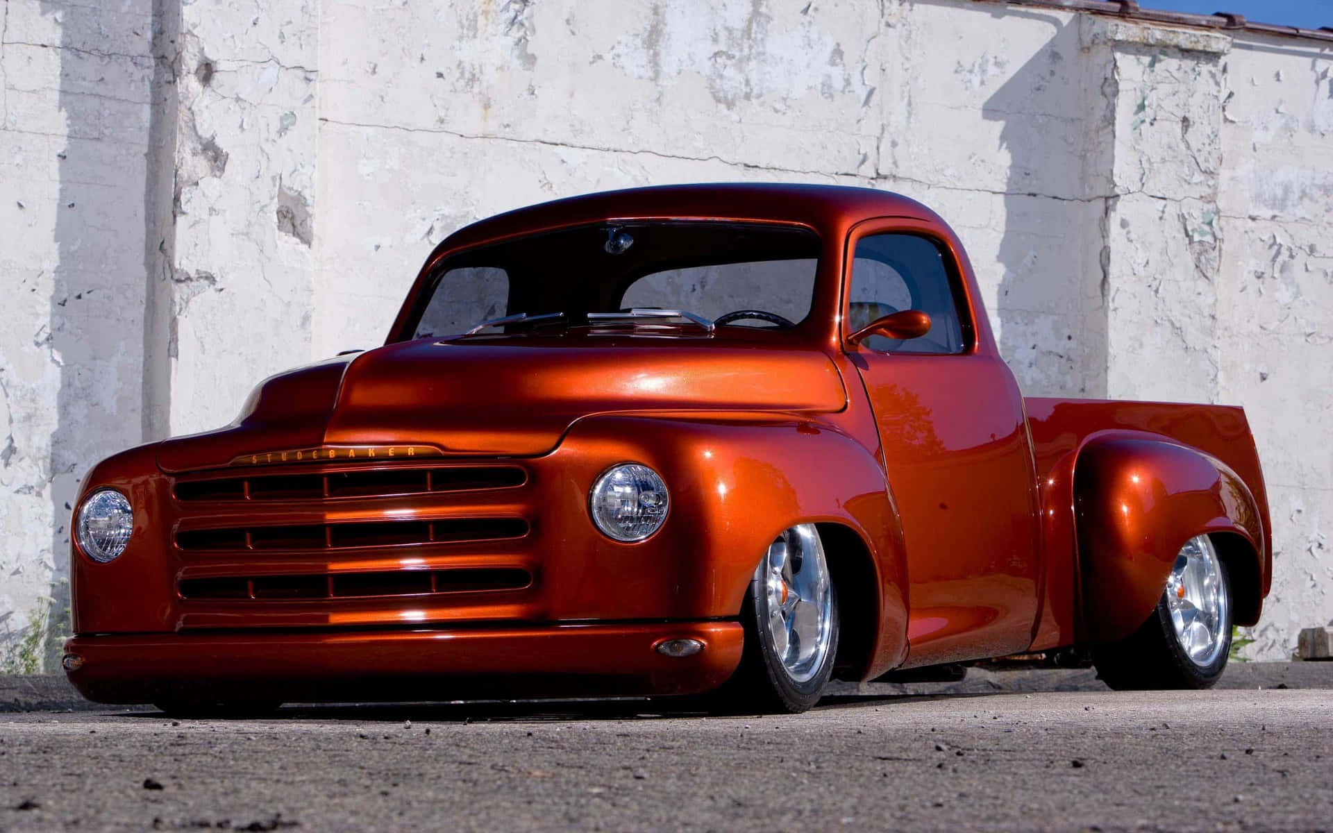 A Red Truck Parked In Front Of A White Wall Background