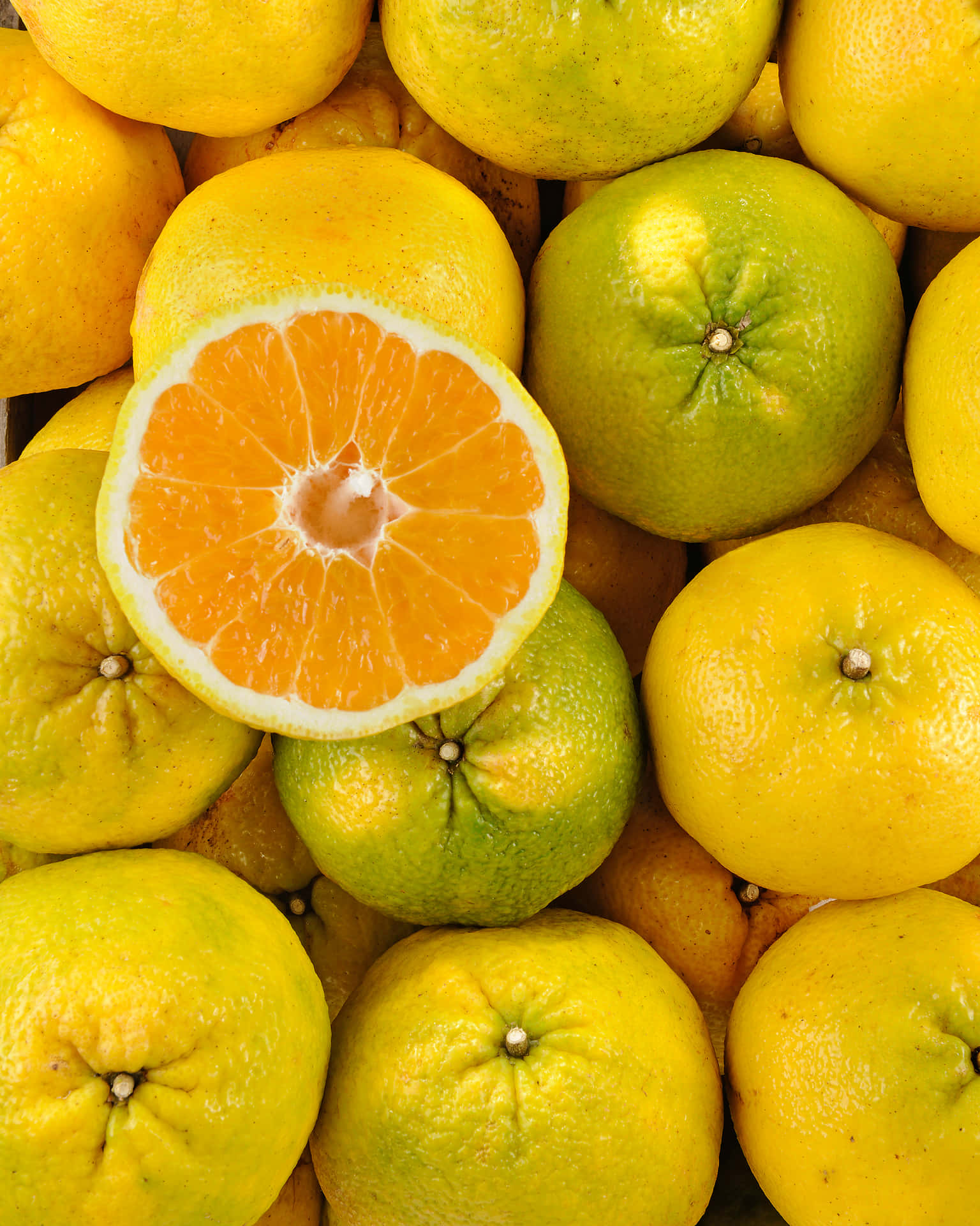 A Refreshing Display Of Whole And Sliced Ugli Fruits Background