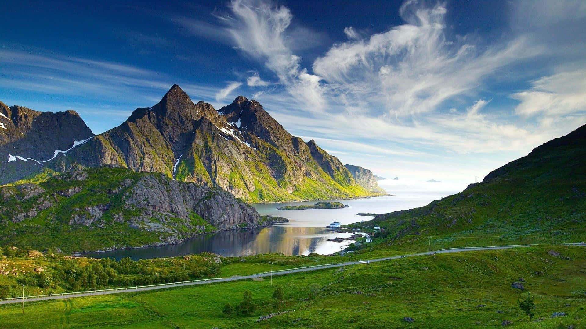 A Road Is Leading To A Lake In The Mountains Background