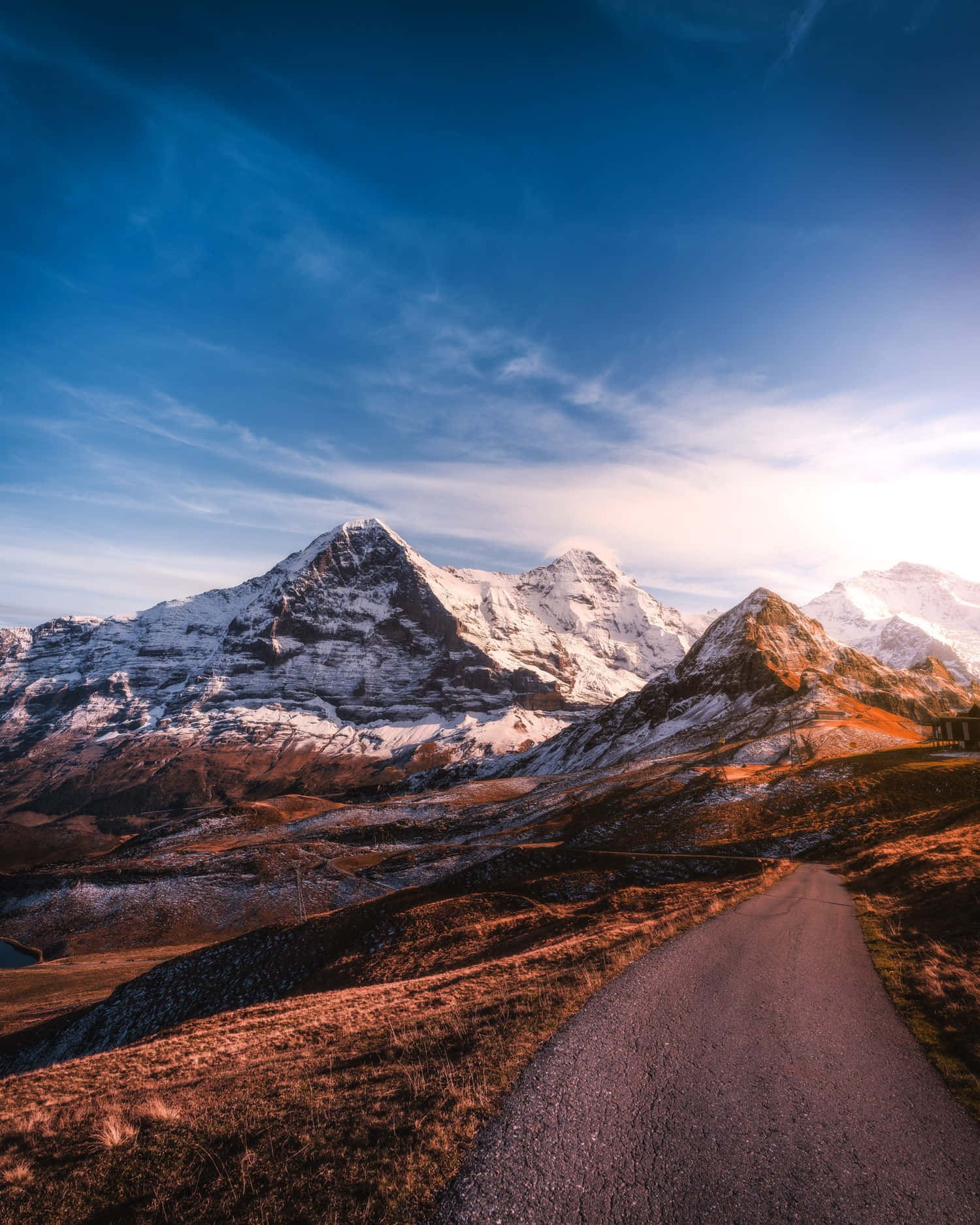 A Road Leading To The Mountains In The Alps Background