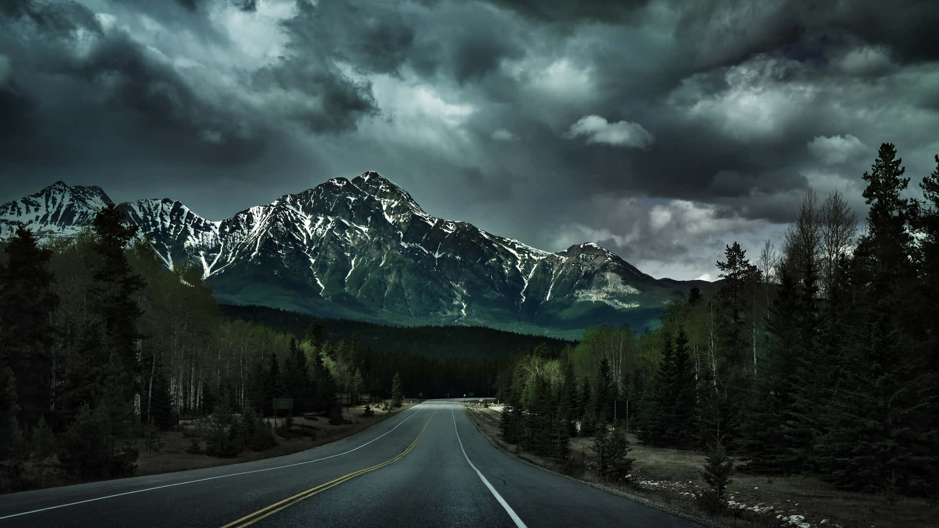 A Road With Mountains And Clouds In The Background Background