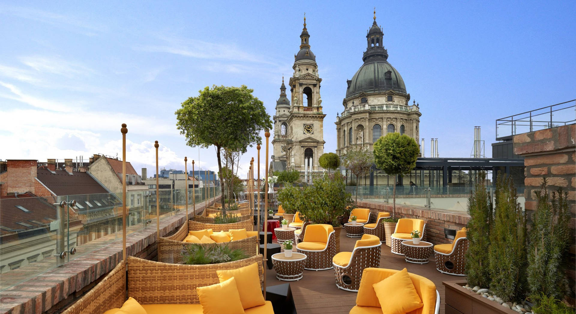 A Rooftop With Yellow Chairs And A Church Background