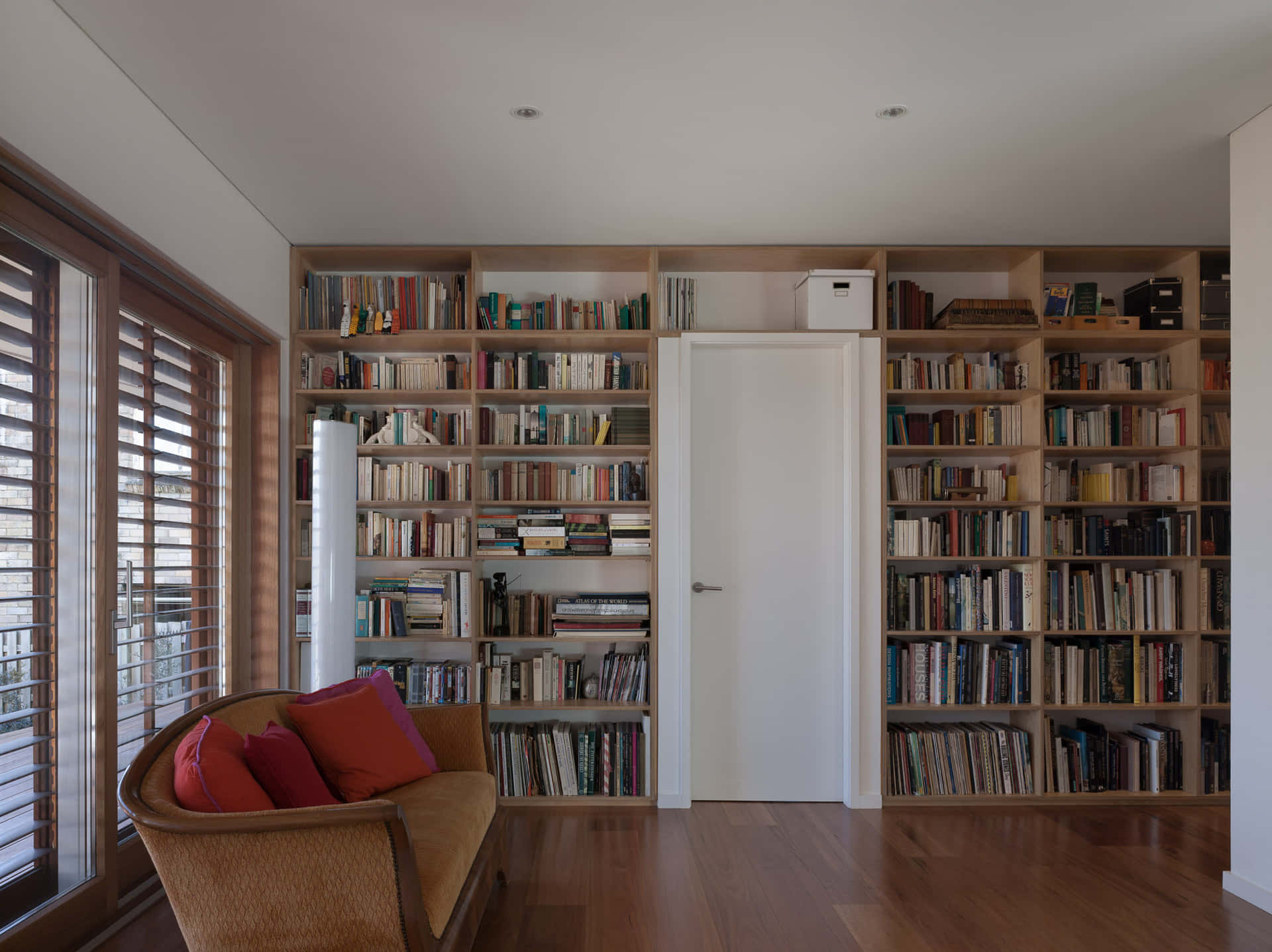 A Room With A Couch And Bookshelves Background