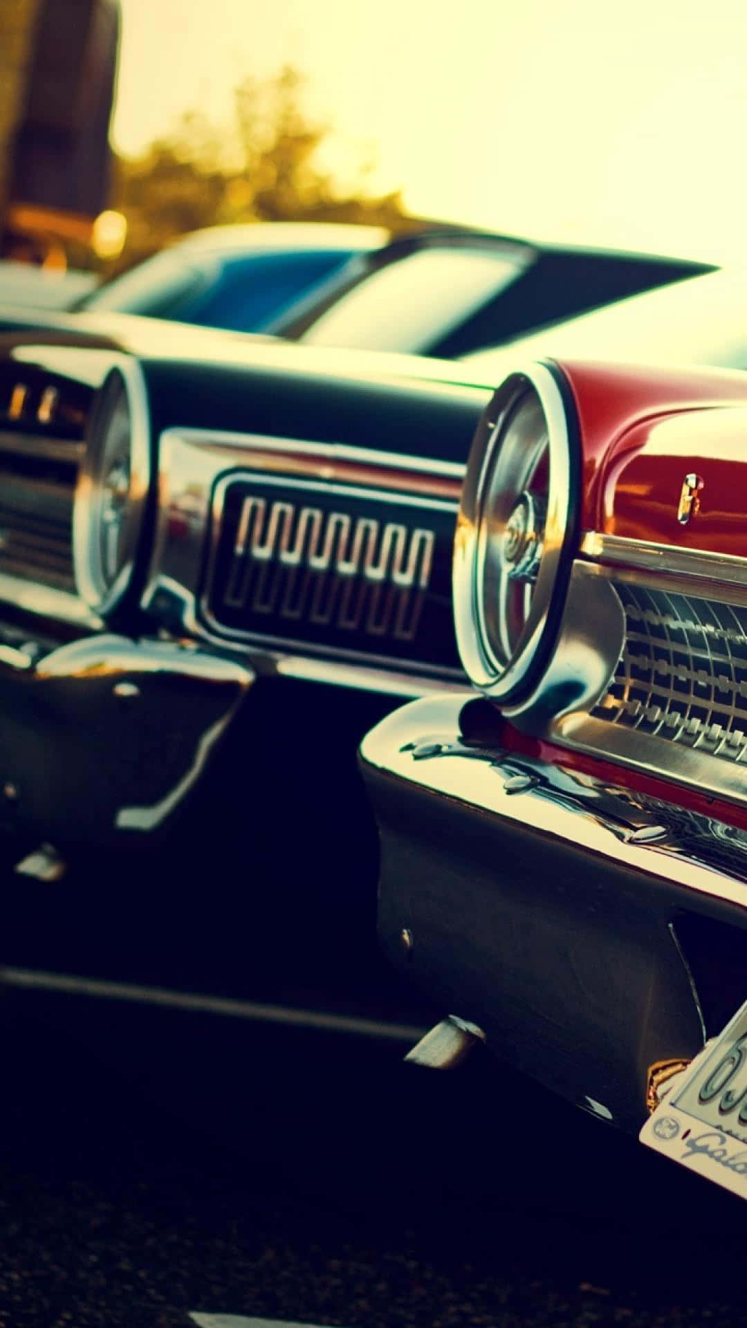 A Row Of Classic Cars Parked In A Parking Lot Background