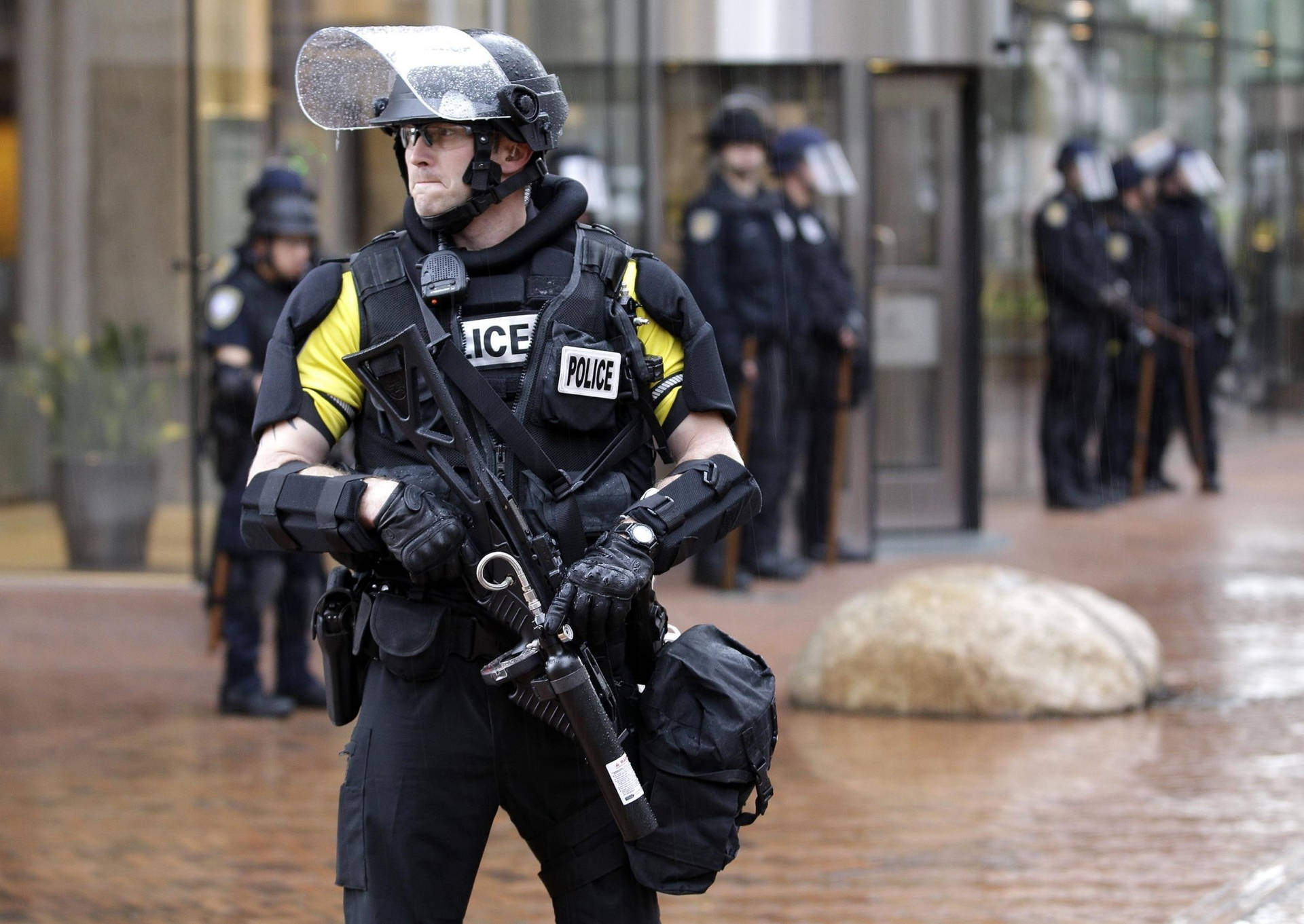 A Seattle Police Officer In Full Riot Gear Background