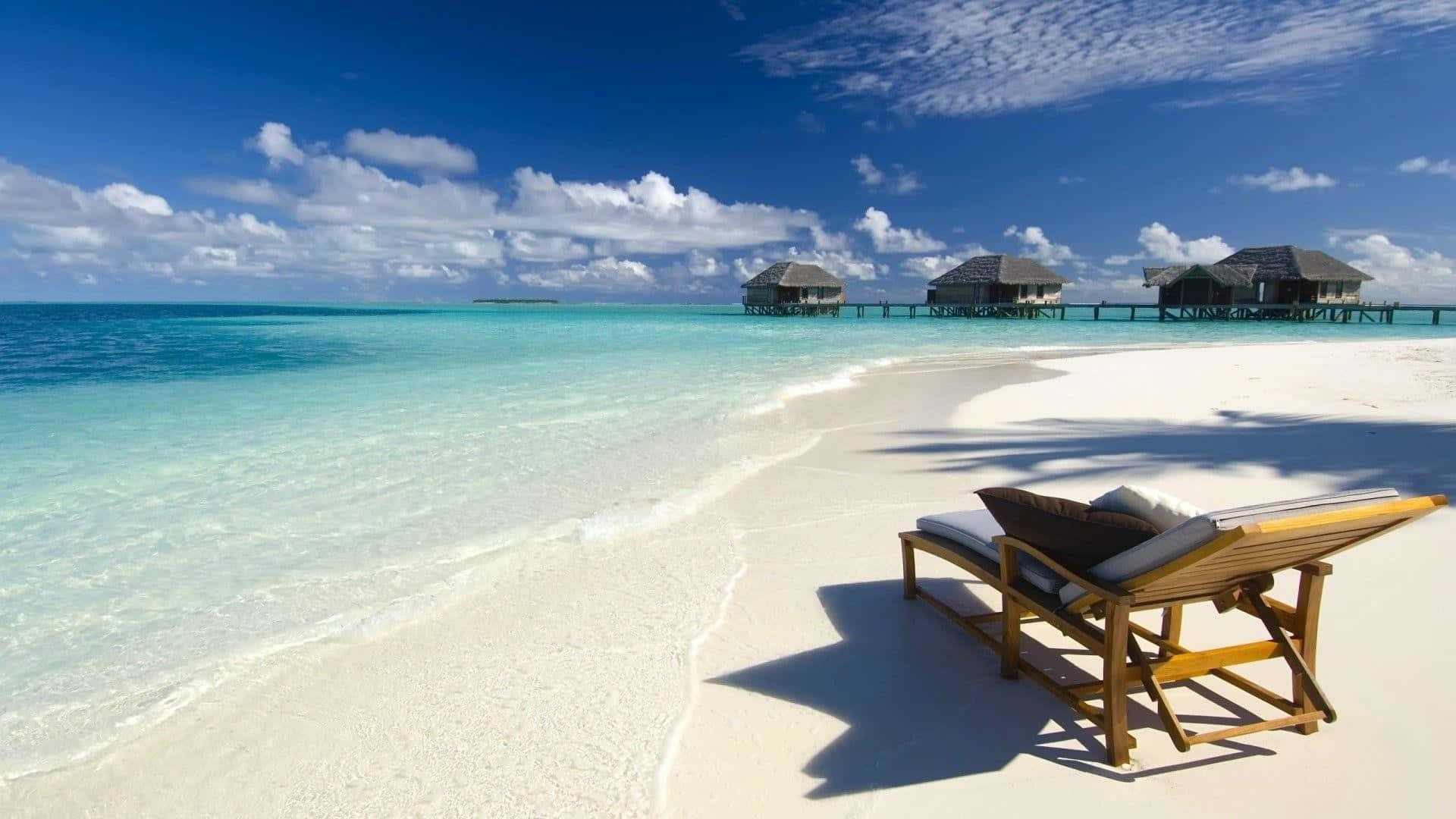 A Serene Sandy Beach At Sunset Background