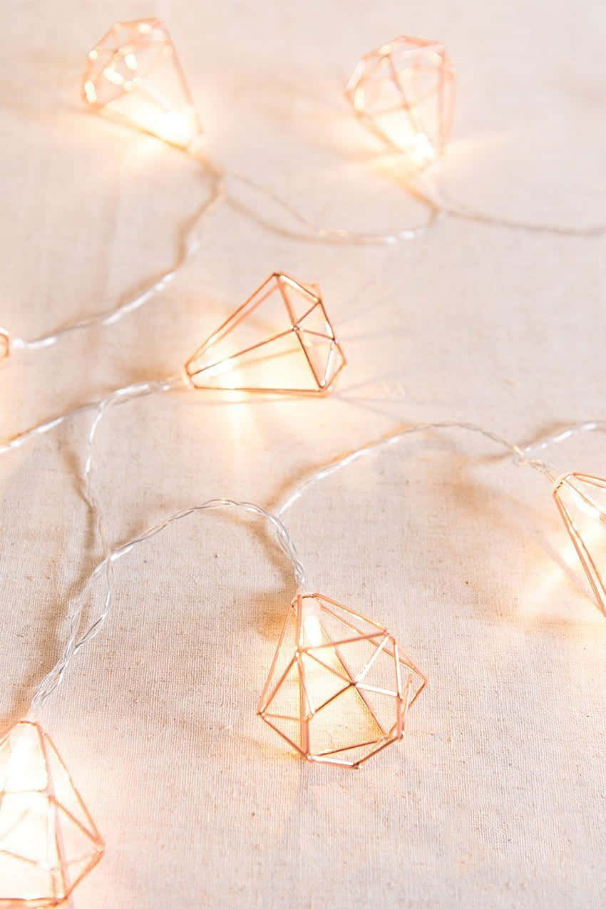 A Set Of Copper Wire Lights With Diamonds On Them Background
