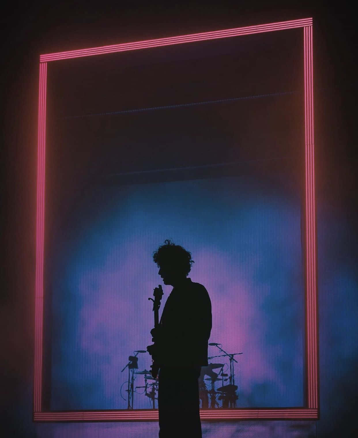 A Silhouette Of A Man Standing In Front Of A Large Neon Frame Background