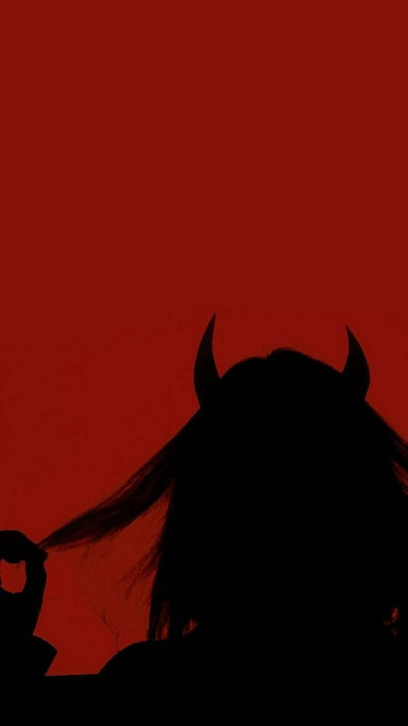 A Silhouette Of A Woman With Horns And A Red Background