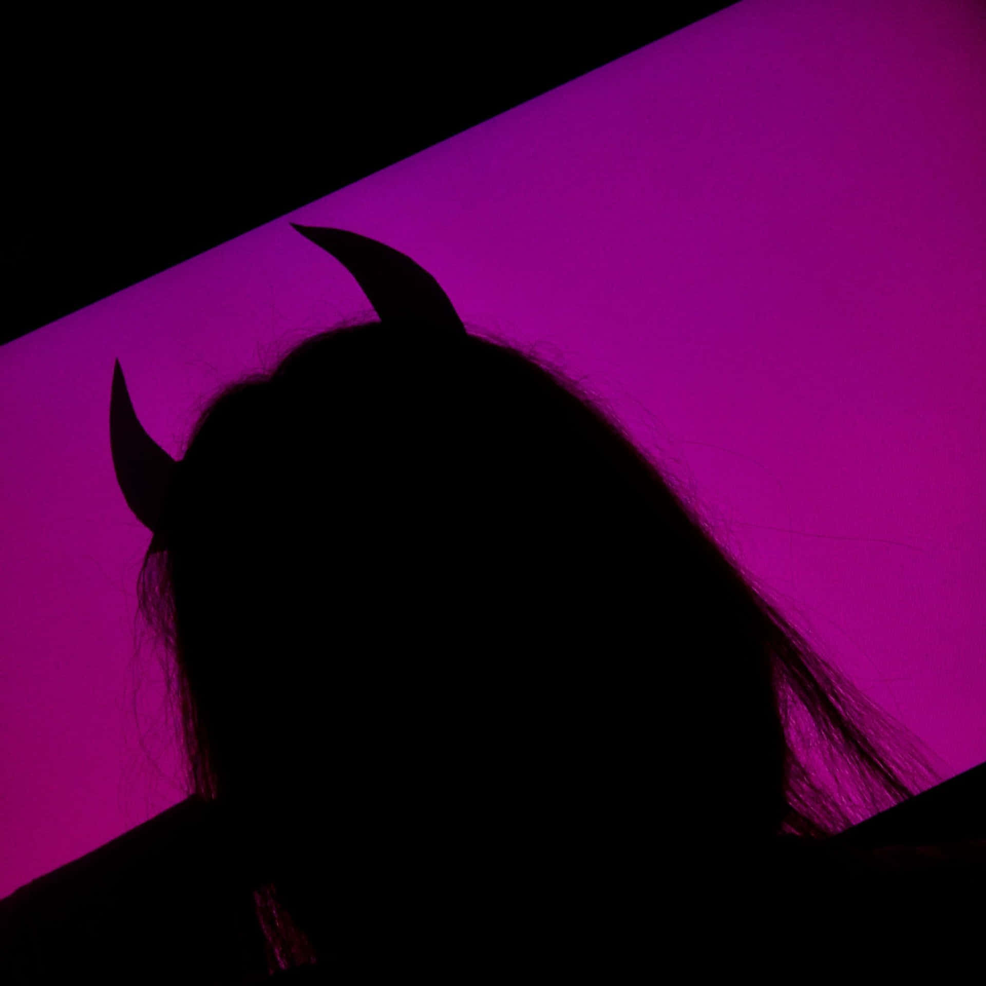 A Silhouette Of A Woman With Horns Background