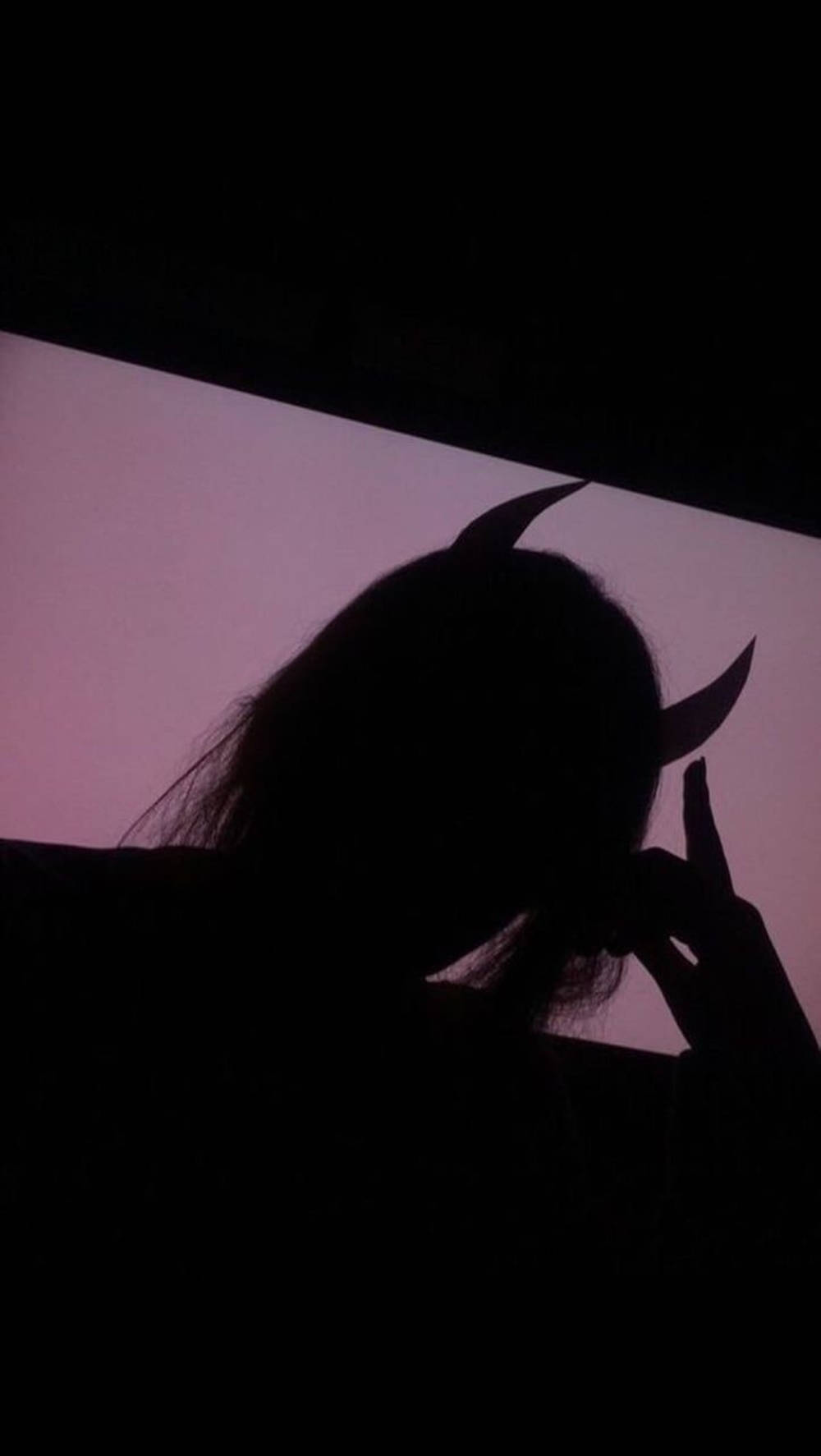 A Silhouette Of A Woman With Horns On Her Head