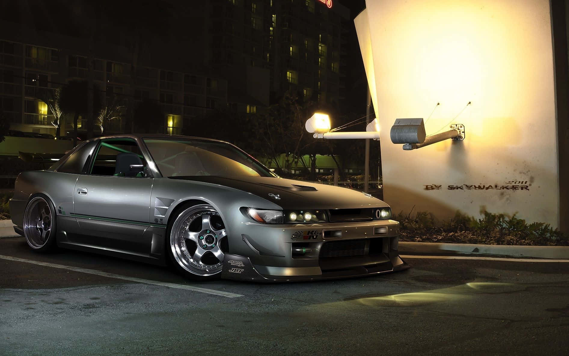 A Silver Car Parked In Front Of A Building At Night Background
