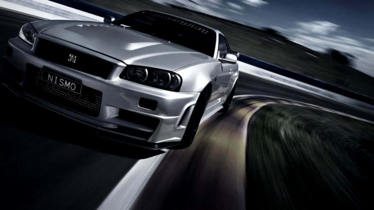 A Silver Sports Car Driving Down A Track Background