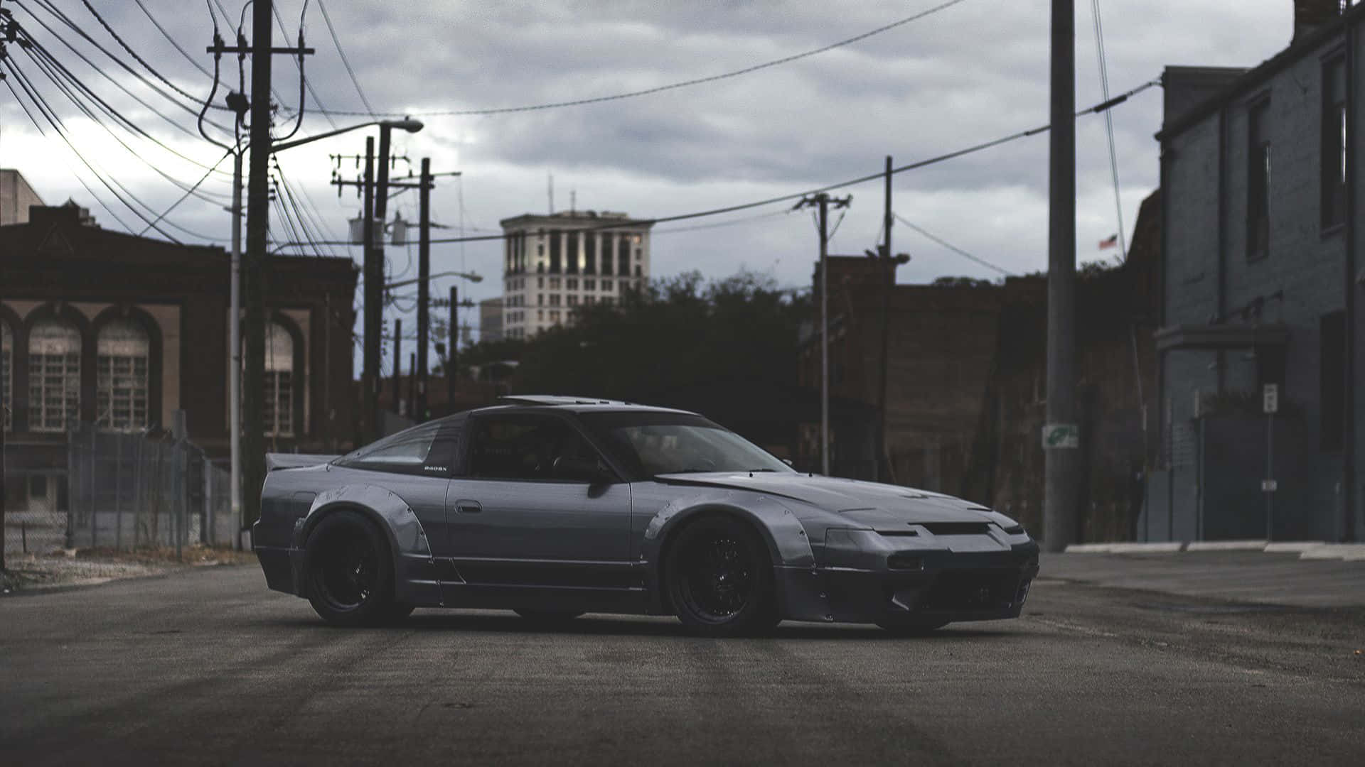 A Silver Sports Car Parked On A Street Background