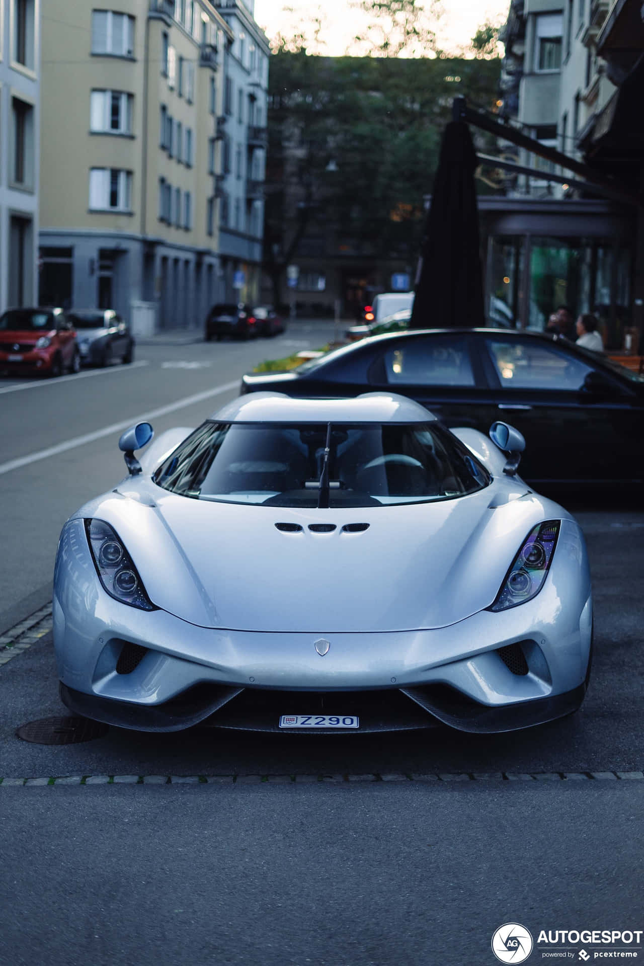 A Silver Sports Car Parked On The Side Of The Street Background
