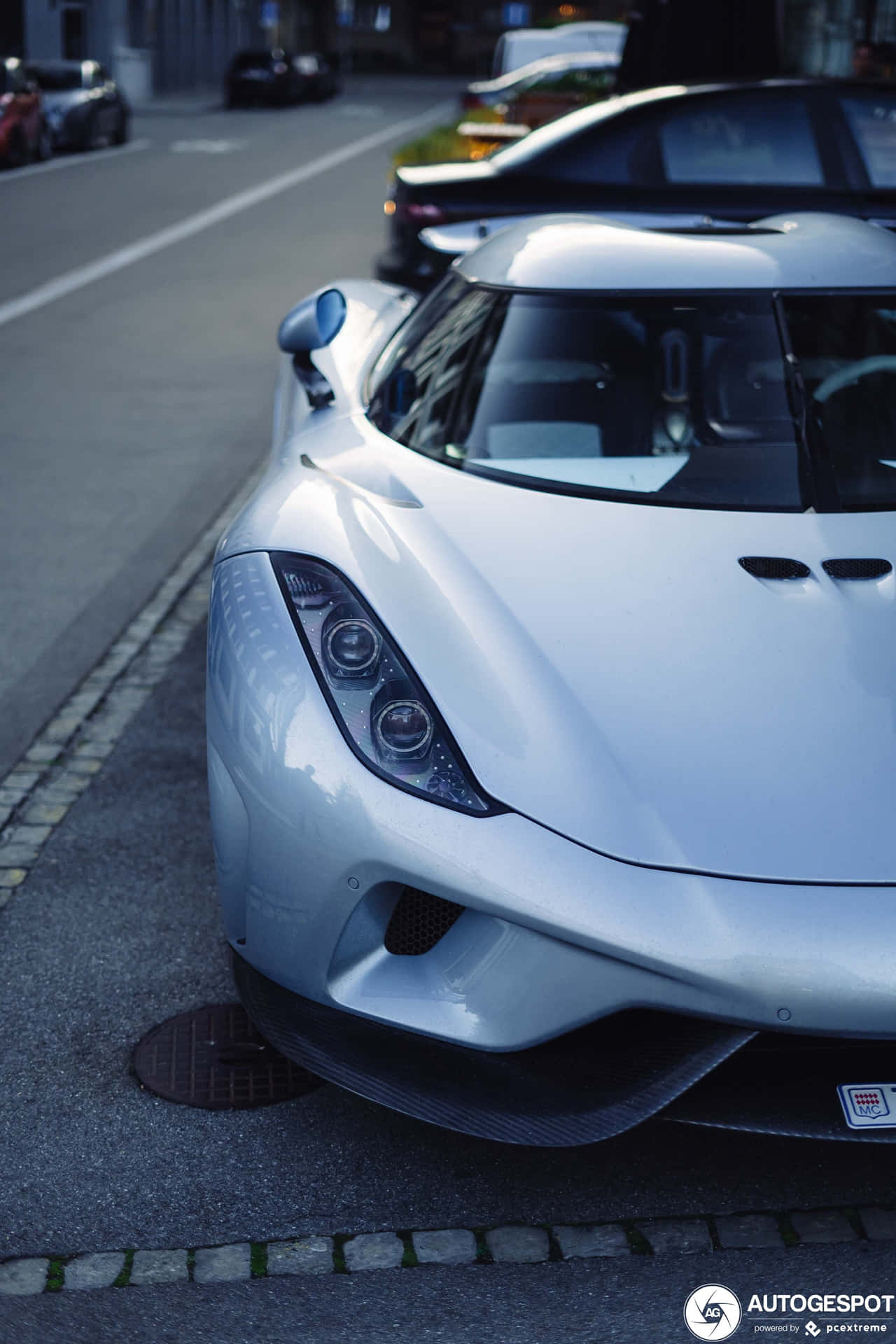A Silver Sports Car Parked On The Side Of The Street Background