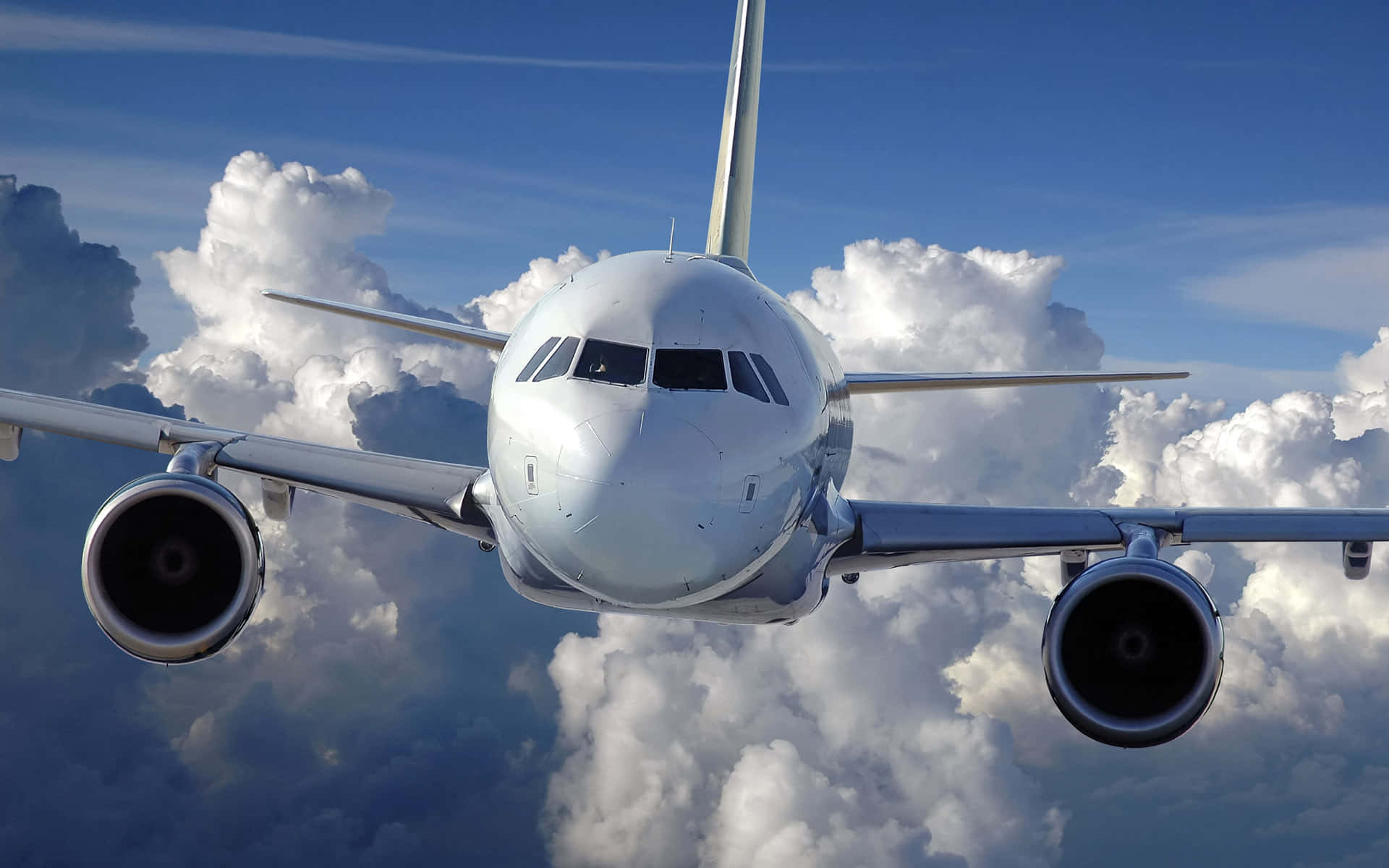 A Sleek And Powerful Jumbo Jet Flying Across The Sky Background