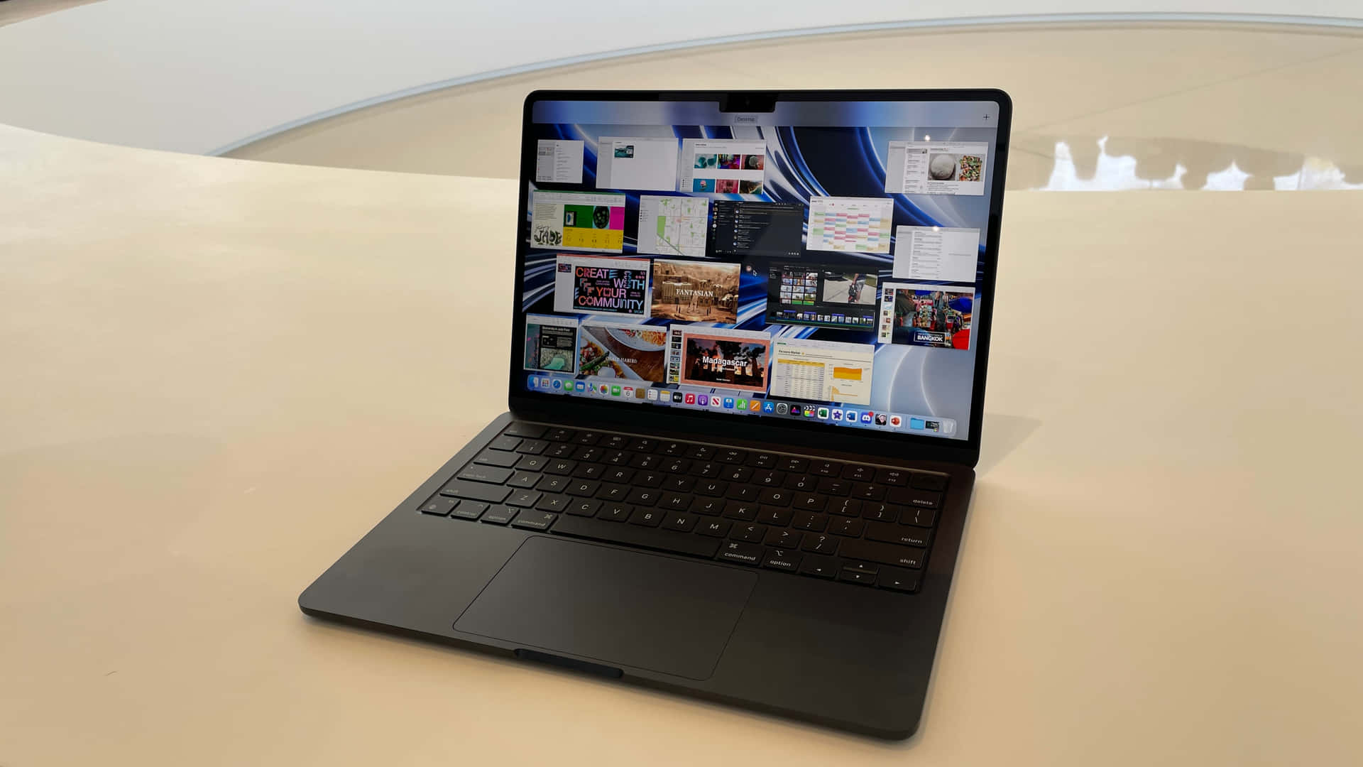 A Sleek Black Macbook On A Silver Desk Background