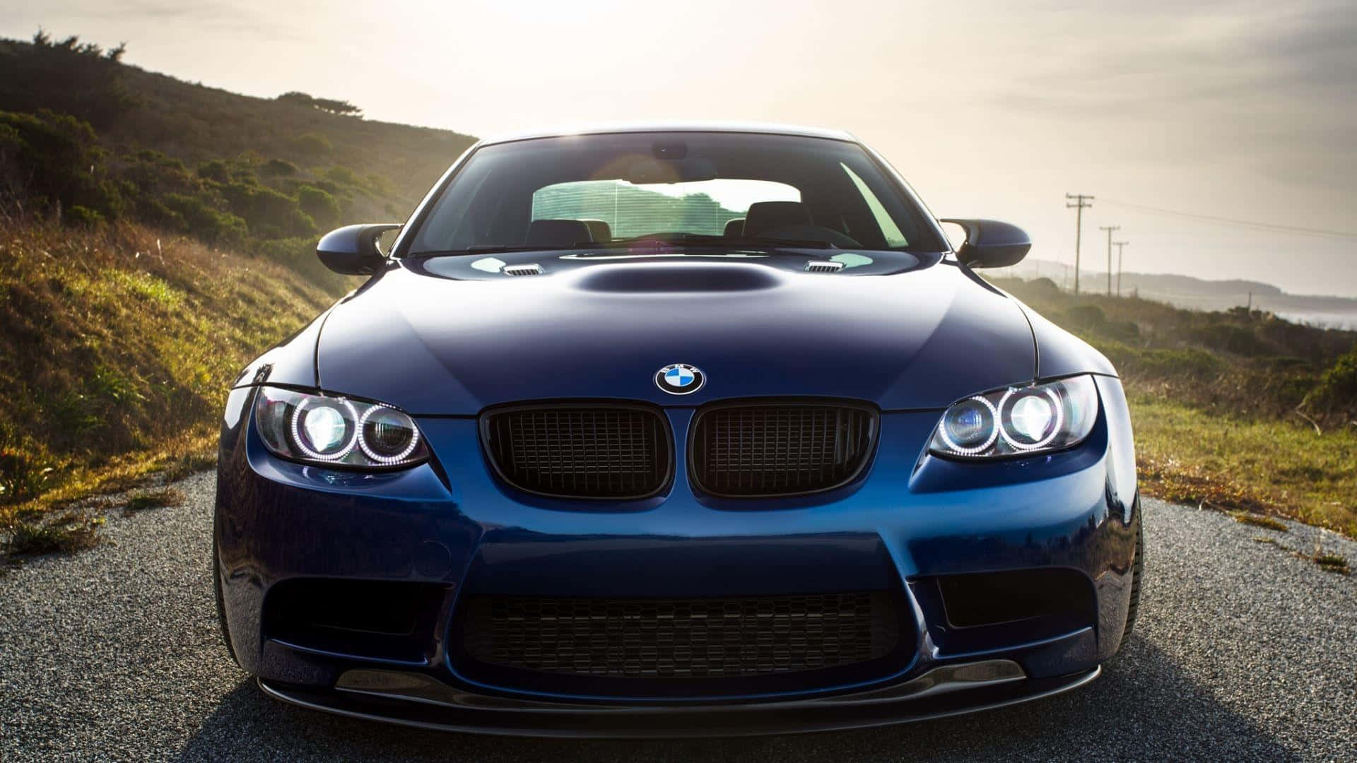 A Sleek Bmw Sports Car Glimmering In The Sunlight Background