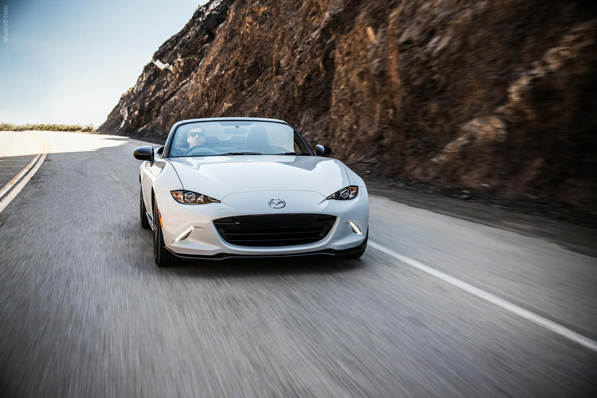 A Sleek Mazda Mx-5 Miata Brilliance On The Open Road Background