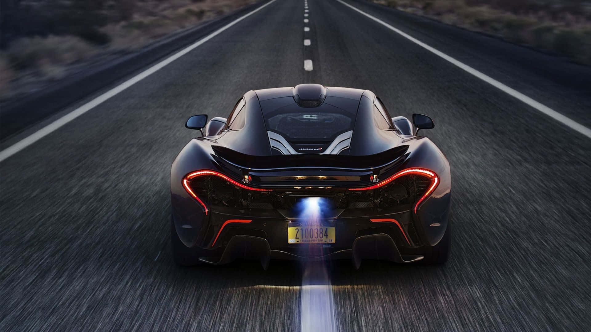A Sleek Race Car Speeding Past A Vibrant Sunset Background
