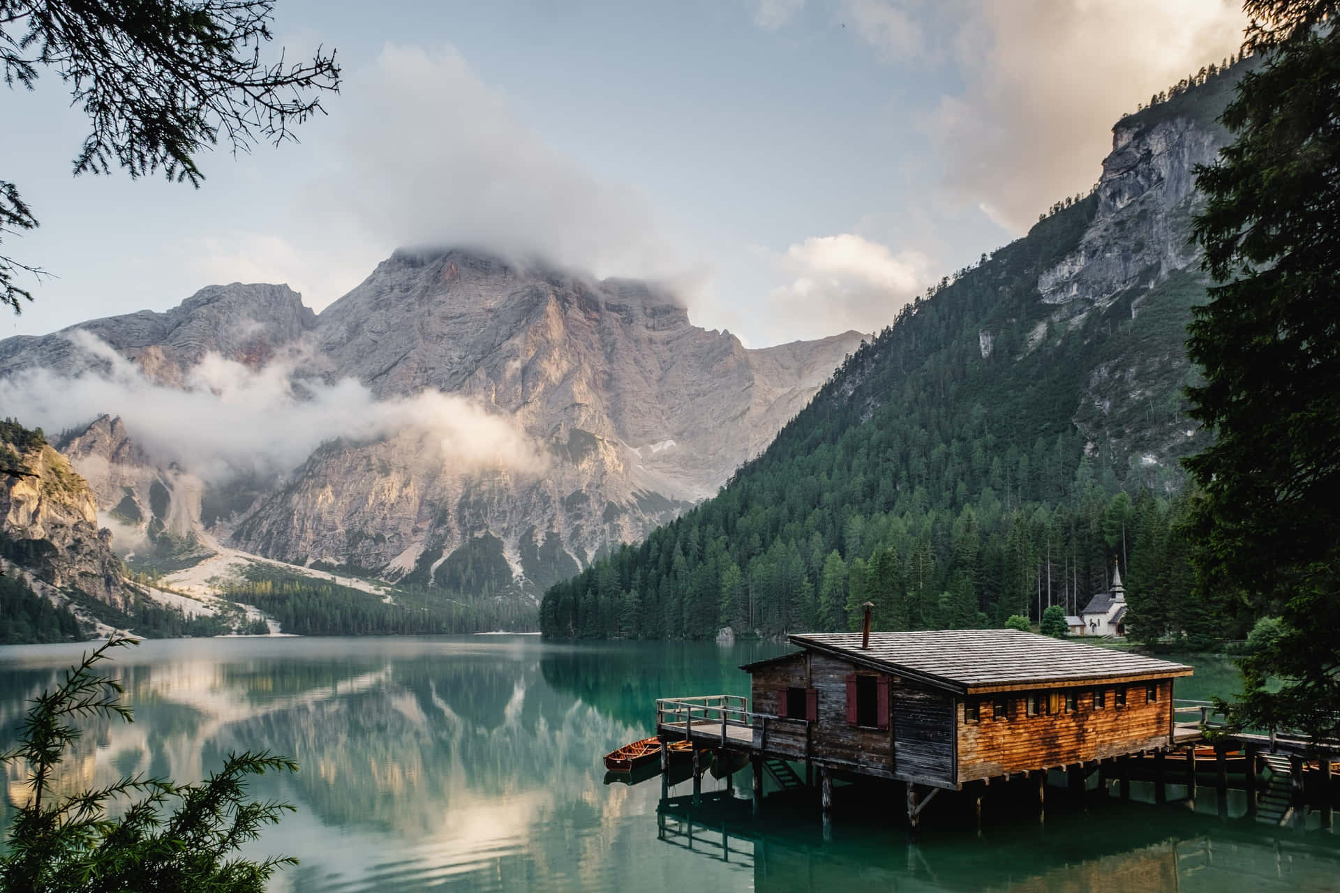 A Small Cabin Sits On A Dock In A Lake Background
