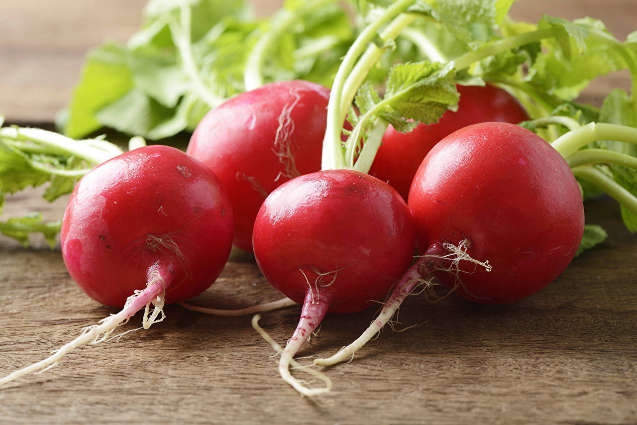 A Small Fresh Radish On A Wooden Surface