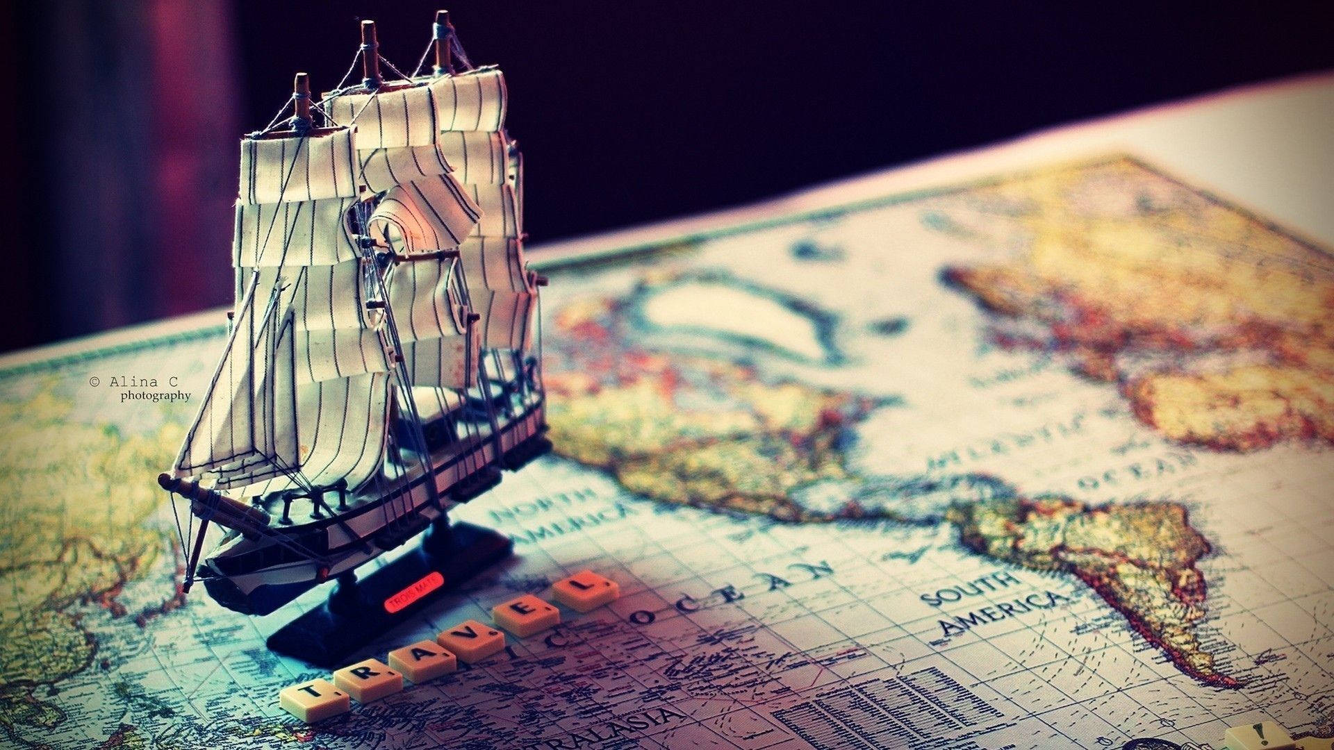 A Small Model Ship On A Map Background