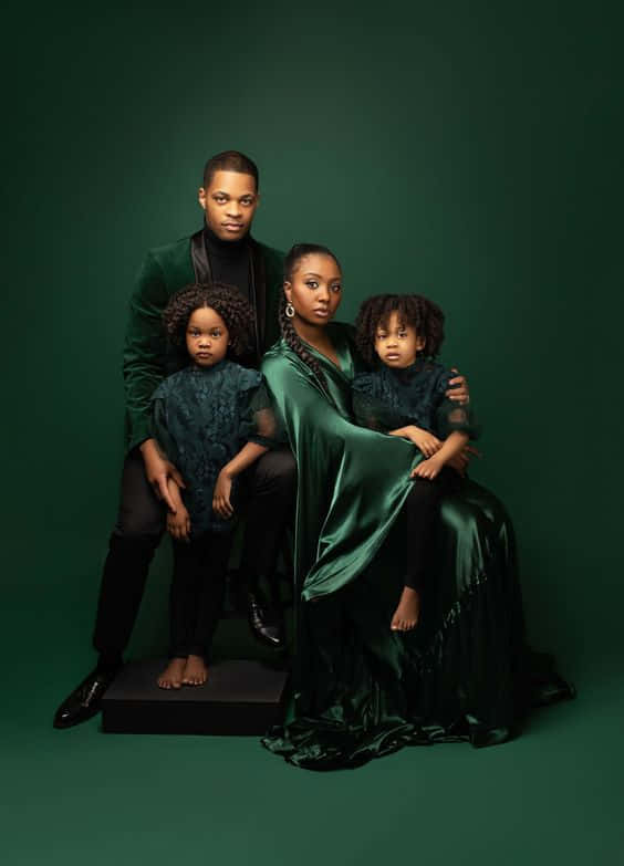 A Smiling Family Of Four In A Cozy Portrait Background