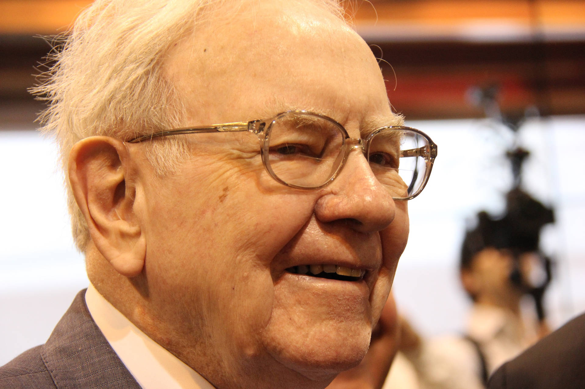 A Smiling Side Profile Of Warren Buffett Background