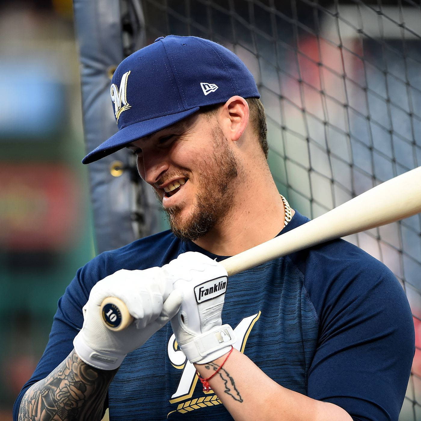 A Smiling Yasmani Grandal Holding A Baseball Bat Background