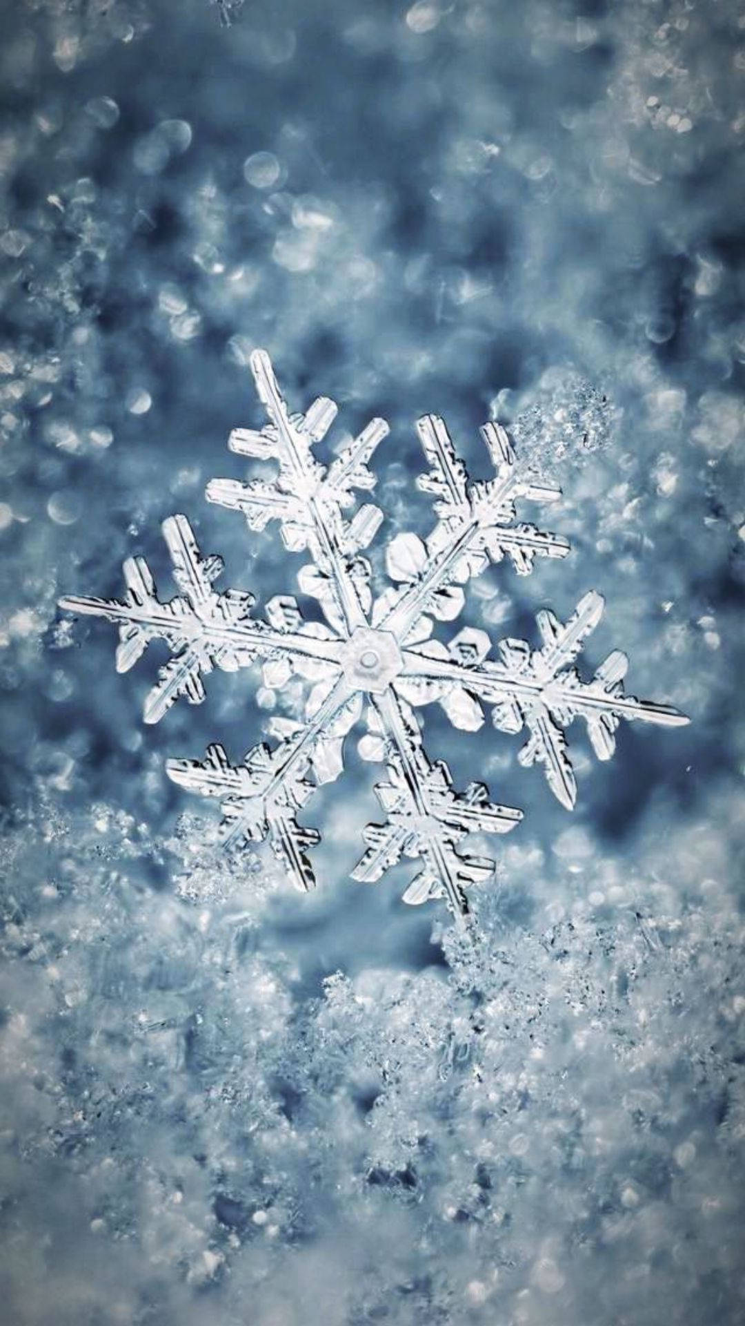 A Snowflake Is Sitting On Top Of A Blue Surface Background